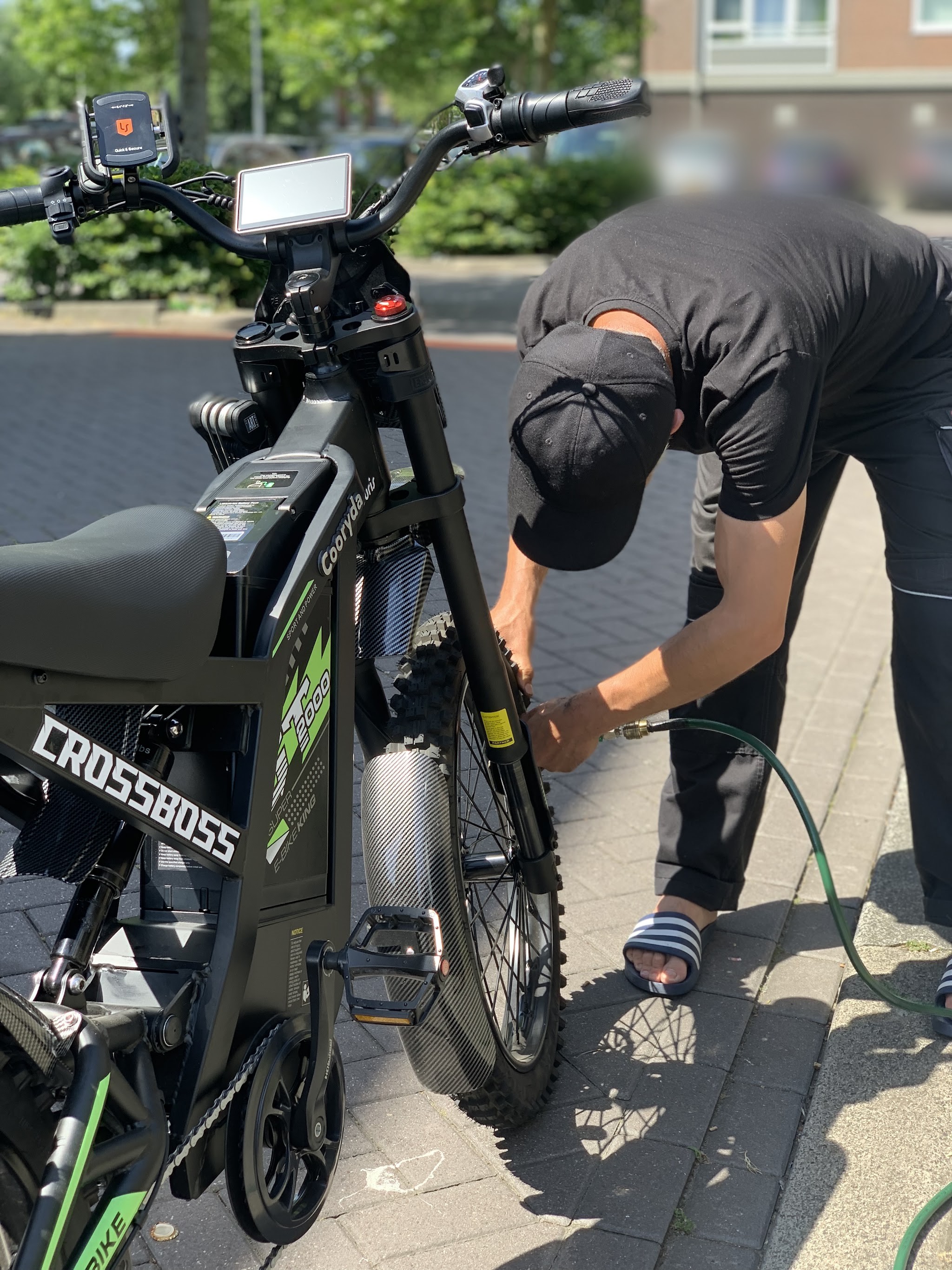 De fietsenmaker pompt de band van een zwarte e-bike op bij de werkplaats