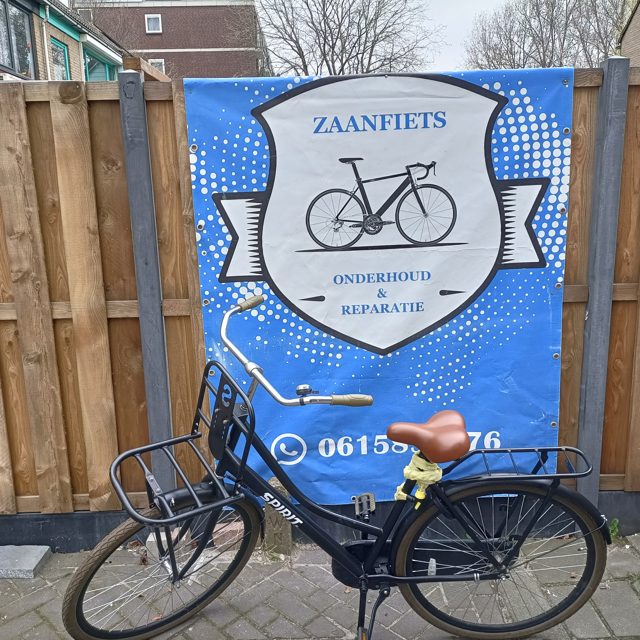 Een zwarte stadsfiets met voordrager voor het Zaanfiets-spandoek